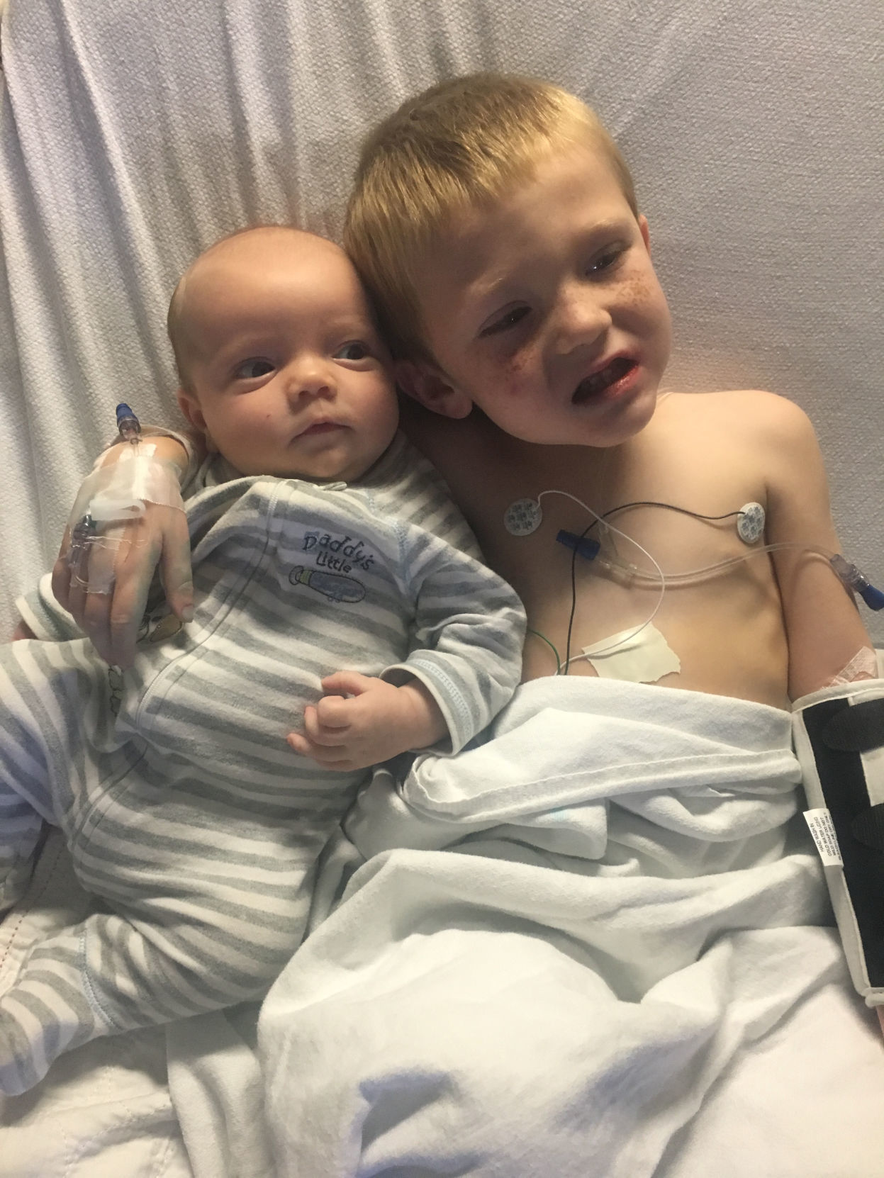 Stephanie Oakley's son hugs his younger brother as he undergoes treatment for pediatric cancer, leaving him vulnerable to mold infection, in this handout photo